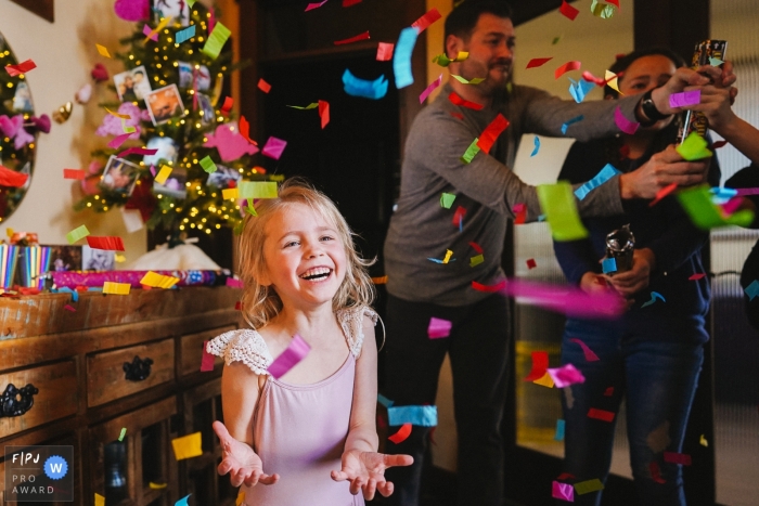 A little girl smiles as confetti falls around her in this photo by a Seattle, WA award-winning family photographer. 