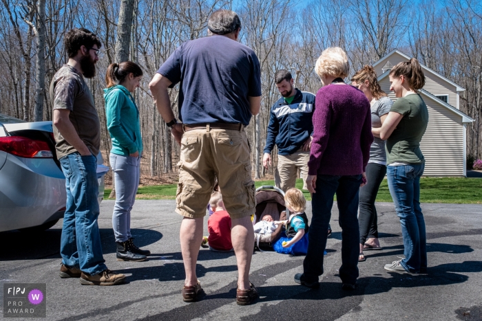 A family watches as two young children meet a newborn baby in this Family Photojournalist Association awarded photo by a Connecticut documentary family photographer.