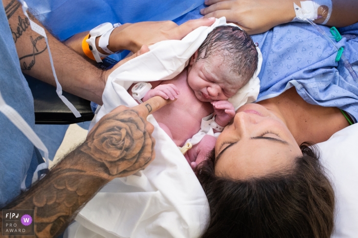 Photo by: <a href="https://www.fpja.com/documentary-family-photography-contests/cibele-piovesan/s%C3%A3o-paulo/2098491">Cibele Piovesan - Brazil</a> A newborn baby holds its father's finger in the hospital in this image composed by an award-winning Sao Paulo, Brazil birth photographer.