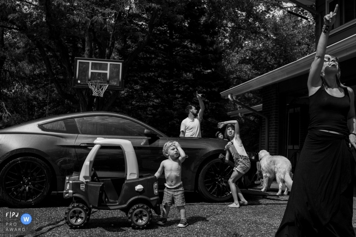 Photo by: <a href="https://www.fpja.com/documentary-family-photography-contests/casie-zalud/boulder/2098781">Casie Zalud - United States</a> A family stands outside looking up and pointing at the sky in this documentary-style family photo captured by a Boulder, CO photographer.