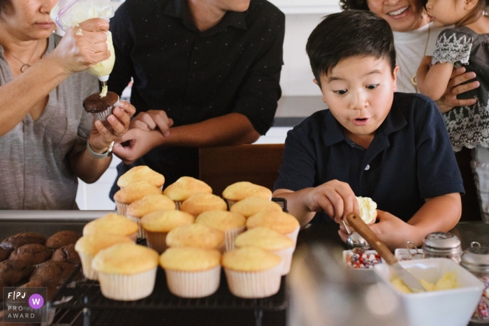 Un garçon aide des petits gâteaux glacés avec sa famille dans cette image primée à la FPJA, capturée par un photographe de famille à Los Angeles, en Californie.