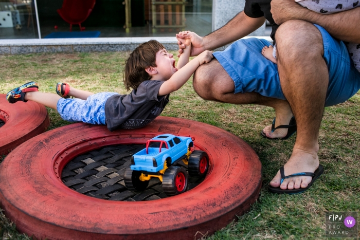 Un photographe de Minas Gerais documente la famille dans leur routine - un père aide son fils dans un moment de frustration à Belo Horizonte