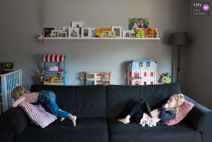 Breda documentary family photography in Noord Brabant - Kids hanging out, waiting for the tablet at home on the couch.