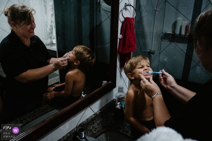 Florianopolis Day in the Life Photographer | Mother brushing her son's teeth in the bathroom of their home.