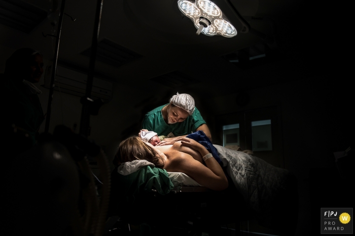 Rio de Janeiro Birth Photography of the first breastfeeding done with the doctor's help in the delivery room.