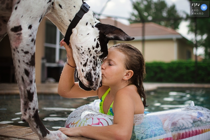 Photo by: <a href="https://www.fpja.com/documentary-family-photography-contests/samantha-moore/sarasota/2100008">Samantha Moore - United States</a> Sarasota family photography | Florida Poolside puppy kisses with a girl and her dog
