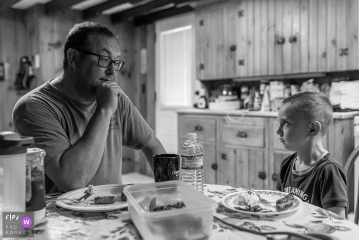 Photo by: <a href="https://www.fpja.com/documentary-family-photography-contests/anna-holden/connecticut/2100207">Anna Holden - United States</a> Connecticut family photojournalism session in home - Dad gives his son "the look" during breakfast.