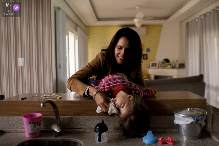 Photo by: <a href="https://www.fpja.com/documentary-family-photography-contests/morgana-secco/london/2100395">Morgana Secco - United Kingdom</a> London documentary family photography - England mother and daughter at the kitchen sink.
