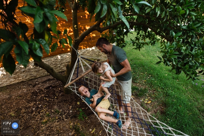 Saint-Pétersbourg, Russie Photographie de famille dans la cour avec papa et les enfants jouant ensemble dans les arbres.