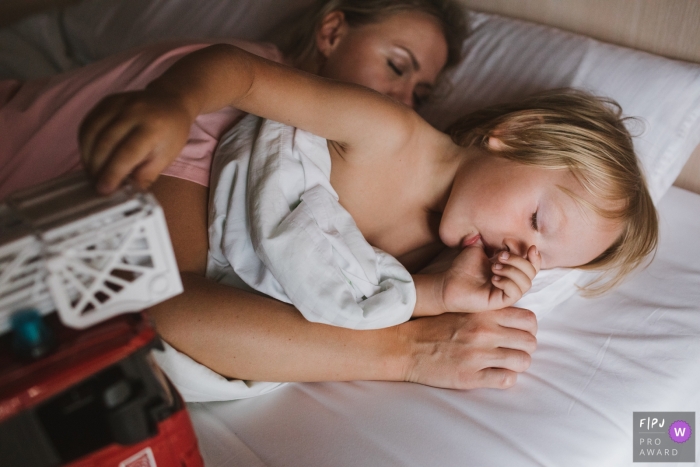 Photo by: <a href="https://www.fpja.com/documentary-family-photography-contests/elena-petrova/saint-petersburg/2100486">Elena Petrova - Russia</a> Saint-Petersburg, Russia documentary family photography of mom and son sleeping.
