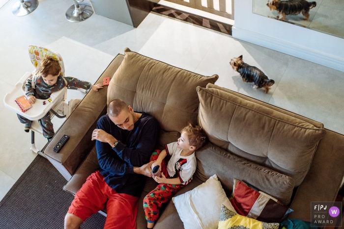 Photo by: <a href="https://www.fpja.com/documentary-family-photography-contests/claudia-ruiz/rio-de-janeiro/2100554">Claudia Ruiz - Brazil</a> Brazil family photo of three brothers hanging out in the livingroom together.