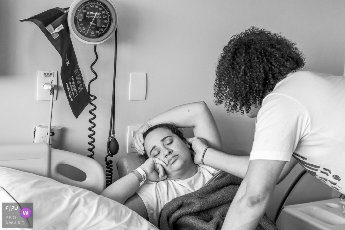 Photo by: <a href="https://www.fpja.com/documentary-family-photography-contests/claudia-ruiz/rio-de-janeiro/2100566">Claudia Ruiz - Brazil</a> Rio de Janeiro Documentary Birth Photography | father stroking mother's face with contraction pain