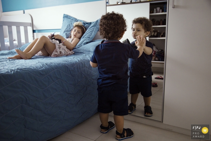 Photo by: <a href="https://www.fpja.com/documentary-family-photography-contests/waleska-battistella/rio-grande-do-sul/2100579">Waleska Battistella - Brazil</a> Rio Grande do Sul family photographer for Brazil - A young boy is Figuring out the mirror.