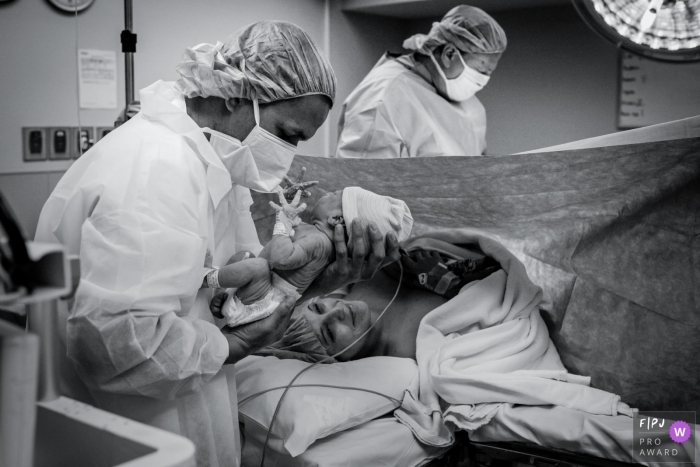 Photo by: <a href="https://www.fpja.com/documentary-family-photography-contests/loren-haar/ventura/2100774">Loren Haar - United States</a> California hospital birth photography - Ventura Dad's first time holding infant baby