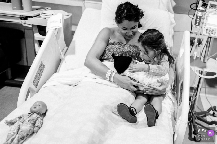 Photo by: <a href="https://www.fpja.com/documentary-family-photography-contests/ron-storer/seattle/2100805">Ron Storer - United States</a> Seattle Washington birthing and family photographer - little girl being shown how to hold baby