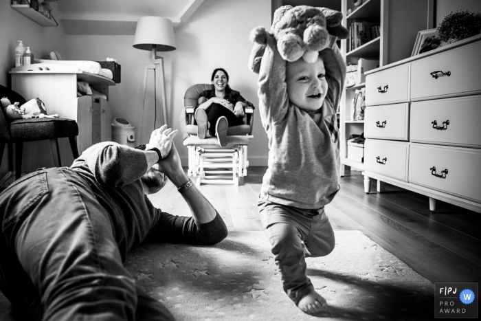 Parents hang out with toddler child as he takes his first steps | Belgium Family Session