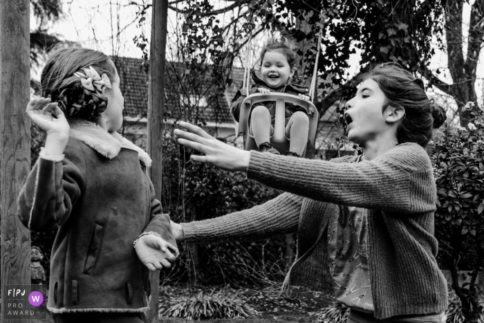 Photo by: <a href="https://www.fpja.com/documentary-family-photography-contests/kobe-vanderzande/limburg/2100900">Kobe Vanderzande - Belgium</a> Flanders Family Photography | children pay in the backyard while young one swings