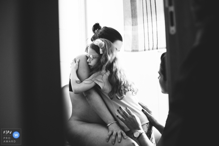 Photo by: <a href="https://www.fpja.com/documentary-family-photography-contests/karoline-saadi/ribeirao-preto/2100912">Karoline Saadi - Brazil</a> daughter and doula taking care of mother in labor | Ribeirao Preto Birth Photography