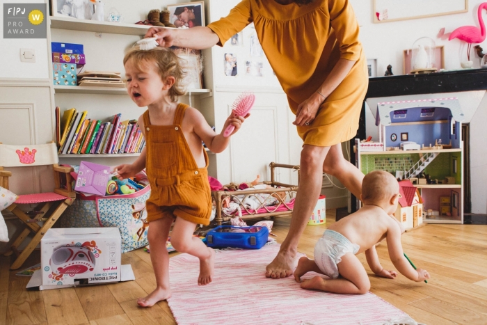 Photo by: <a href="https://www.fpja.com/documentary-family-photography-contests/annie-gozard/paris/2100936">Annie Gozard - France</a> Young girl runs away, escaping mom as she tries to brush girl's hair | Paris Family Photo