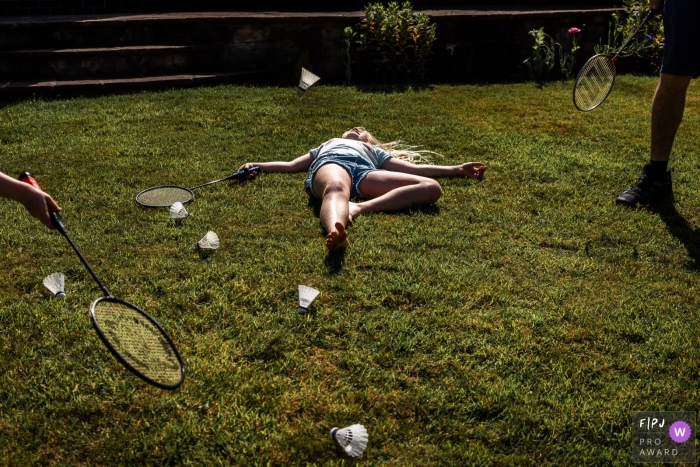  Playing badminton in England while a family photographer takes pictures