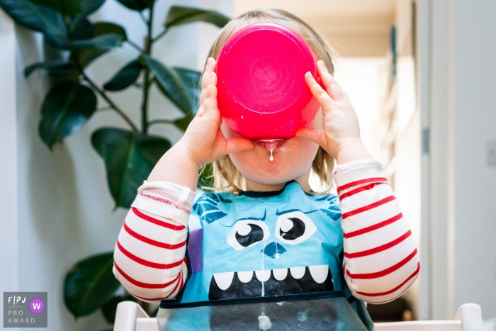 Photo by: <a href="https://www.fpja.com/documentary-family-photography-contests/linda-mauch/kent/2101134">Linda Mauch - United Kingdom</a> England in home family picture session | Girl drinking milk from a cereal bowl