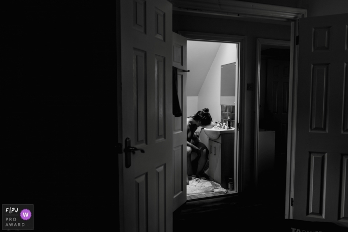Photo by: <a href="https://www.fpja.com/documentary-family-photography-contests/sharron-gibson/buckinghamshire/2101242">Sharron Gibson - United Kingdom</a> Exhausted after the birth, new mum must go to the toilet before the midwives can leave. | UK birth photography