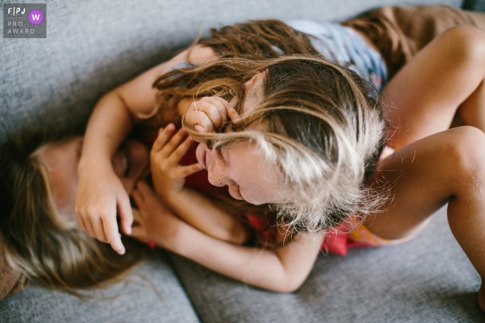 Photo by: <a href="https://www.fpja.com/documentary-family-photography-contests/jolanda-boer/zuid-holland/2101246">Jolanda Boer - Netherlands</a> Zuid Holland Day in the life photo session with two girls playing on the couch.