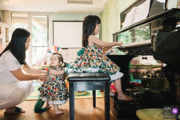 Photo by: <a href="https://www.fpja.com/documentary-family-photography-contests/leon-wong/hangzhou-city/2101326">Leon Wong - China</a> Mom accompanied the babies to play the piano at home | China family photography