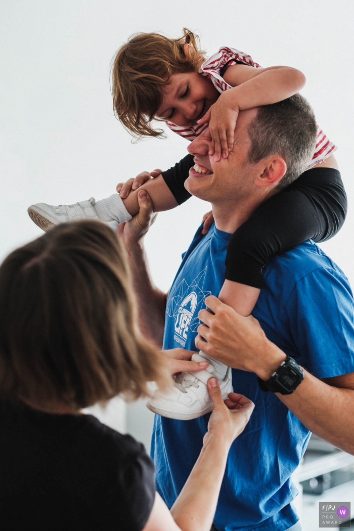 Antwerpen Flanders family picture sessions - Poking dad's eyes whilst putting on shoes