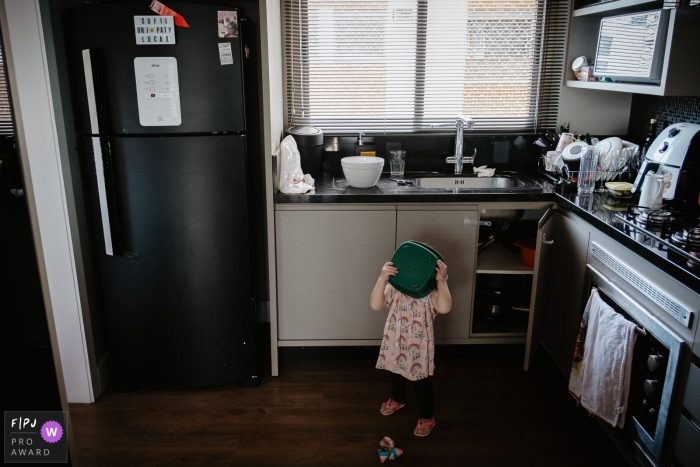 Santa Catarina Child in the kitchen with plastic bowl on the head. Brazil family pictures.