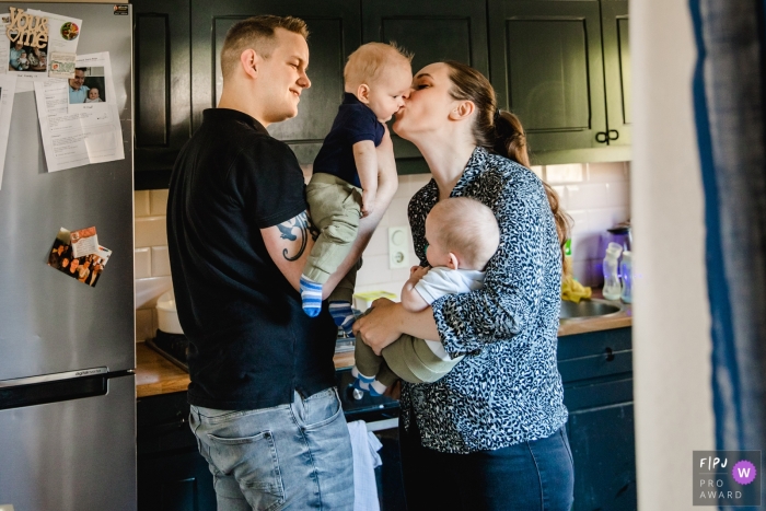 Photo by: <a href="https://www.fpja.com/documentary-family-photography-contests/hiske-boon/noord-brabant/2101406">Hiske Boon - Netherlands</a> Netherlands family photo session - A moment with twins, in the kitchen, with a kiss from mom.