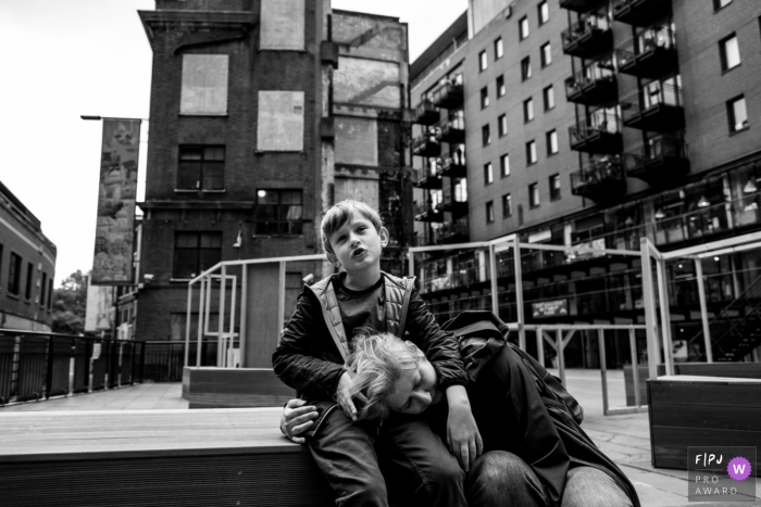 Photo by: <a href="https://www.fpja.com/documentary-family-photography-contests/raluca-chase/essex/2101459">Raluca Chase - United Kingdom</a> England Mom resting her head on her son's lap on a cold London day | Photography session from Essex family photographer