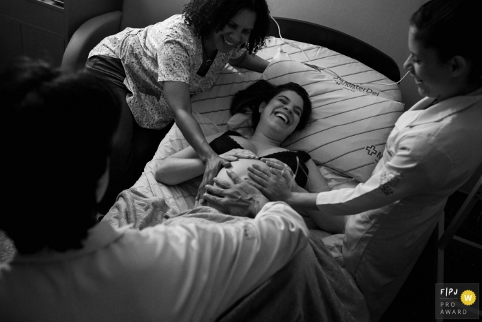 Photo by: <a href="https://www.fpja.com/documentary-family-photography-contests/adriana-costa/belo-horizonte/2101480">Adriana Costa - Brazil</a> Minas Gerais mom-to-be in labor receiving affection from her medical team | Minas Gerais birthing photography session.