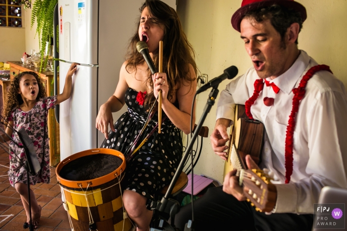 Minas Gerais excited singing girl with musicians couple - Family party photography for Brazil.