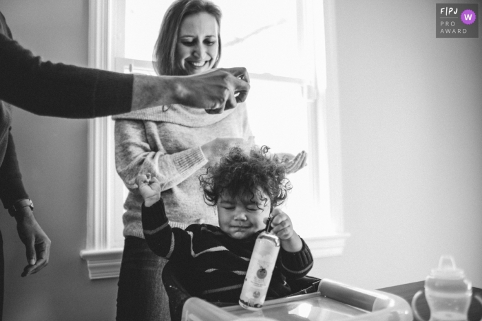 Photo by: <a href="https://www.fpja.com/documentary-family-photography-contests/natasha-lamalle/washington-dc/2101506">Natasha Lamalle - United States</a> Washington DC family photo session | Dad is spraying his son's hair during his breakfast.