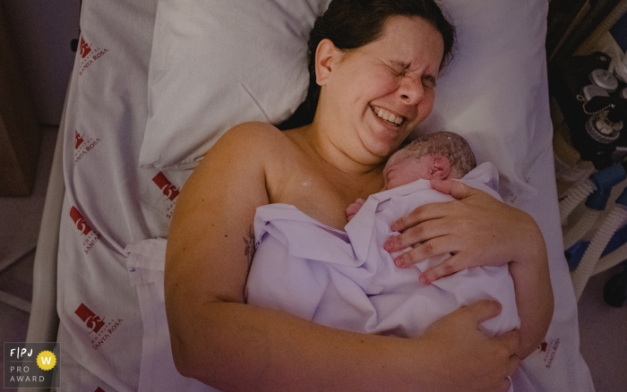 Photo by: <a href="https://www.fpja.com/documentary-family-photography-contests/lisandro-castro/cuiab%C3%A1/2101517">Lisandro Castro - Brazil</a> Mato Grosso birthing session photography of mom holding her newborn baby.