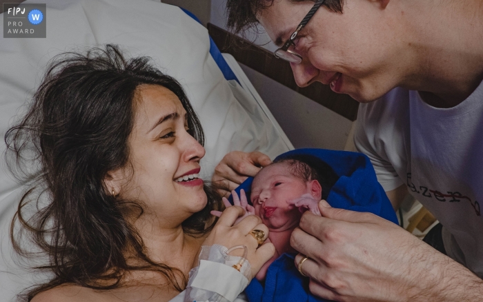 Photo by: <a href="https://www.fpja.com/documentary-family-photography-contests/lisandro-castro/cuiab%C3%A1/2101542">Lisandro Castro - Brazil</a> Mom and dad in the hospital holding their new baby - Mato Grosso birth photos.