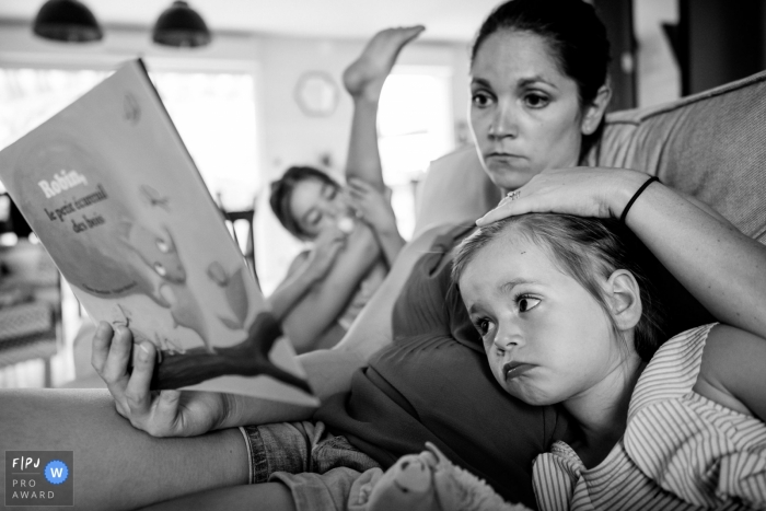 Photo by: <a href="https://www.fpja.com/documentary-family-photography-contests/sybil-rondeau/nantes/2101575">Sybil Rondeau - France</a> Nantes Day in the Life Photographer | Reading time for a mum and her two daughters.