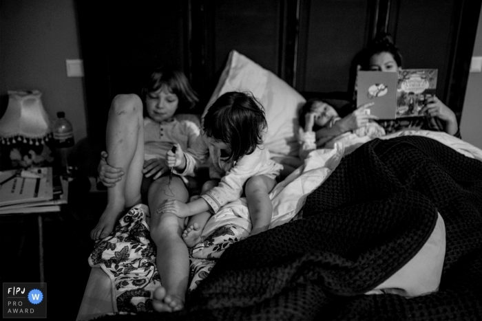 Photo by: <a href="https://www.fpja.com/documentary-family-photography-contests/frederikke-brostrup/copenhagen/2101666">Frederikke Brostrup - Denmark</a> Denmark mom reads a Good night story to the kids...family photography