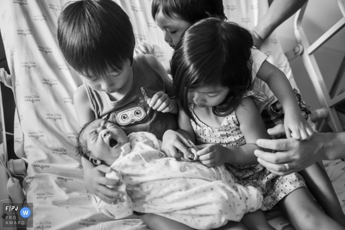 Siblings huddle around new baby to the family | Brazil Family Photo Session