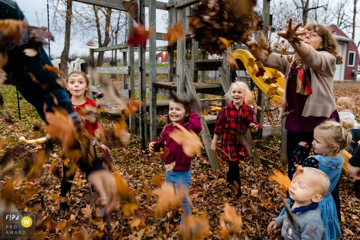 Photo by: <a href="https://www.fpja.com/documentary-family-photography-contests/ang-waterton/ontario/2101830">Ang Waterton - Canada</a> Fall time leaf fight with the family | Ontario Family Sessions