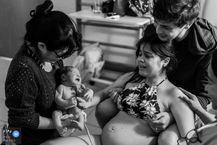 Grandma holds baby right after mom gives birth to newborn | Brazil Birthing Photography