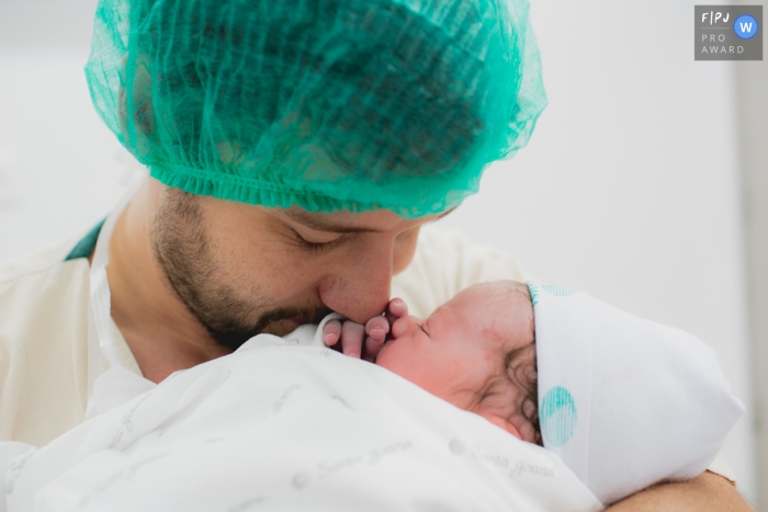Photo by: <a href="https://www.fpja.com/documentary-family-photography-contests/ana-paula-faria/sao-paulo/2101886">Ana Paula Faria - Brazil</a> A father cuddles with his newborn baby | Sao Paulo Birth Photography