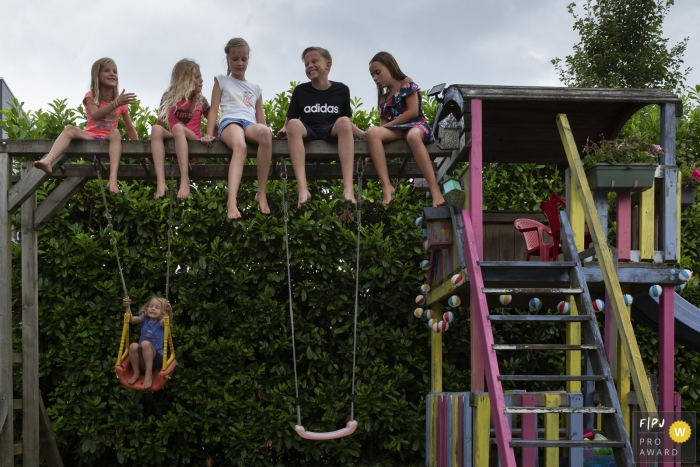 Photo by: <a href="https://www.fpja.com/documentary-family-photography-contests/natasja-de-nijs/breda/2101918">Natasja de Nijs - Netherlands</a> Kids sit up on the top of playground equipment | Breda Family Photography