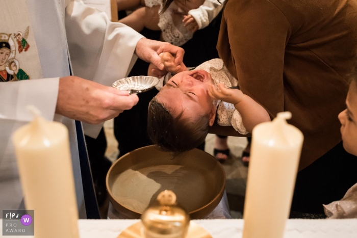 Child cries during his baptism at the church in France.