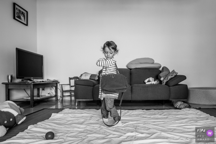 Photo by: <a href="https://www.fpja.com/documentary-family-photography-contests/nadine-court/savoie/2102143">Nadine Court - France</a> Little lady carries a purse over her shoulder | Savoie Family Photography