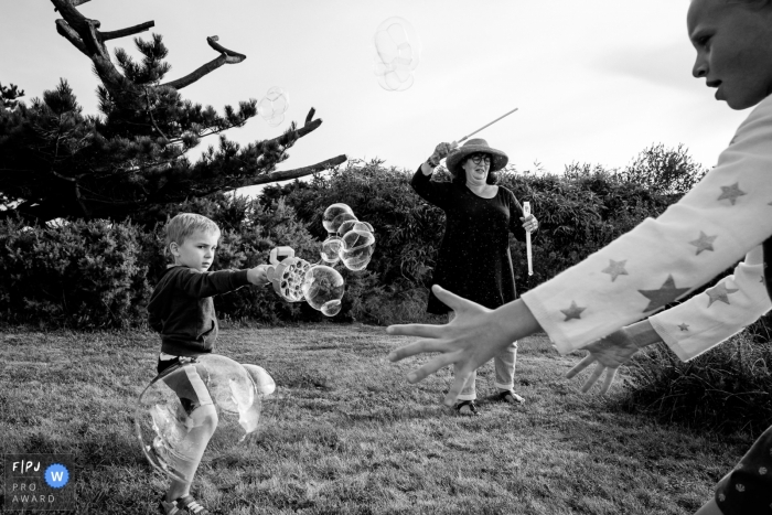 Photo by: <a href="https://www.fpja.com/documentary-family-photography-contests/sybil-rondeau/nantes/2102207">Sybil Rondeau - France</a> Family plays together with bubbles | Nantes Family Photographer