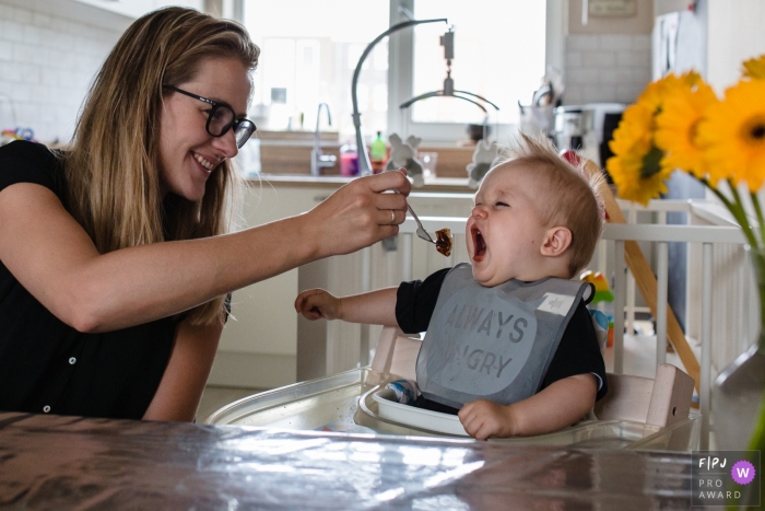 Mother is feeding her "always hungry" young boy in the kitchen | Zuid Holland Family Photography