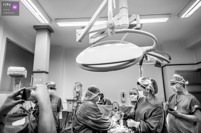 Photo by: <a href="https://www.fpja.com/documentary-family-photography-contests/ta%C3%ADs-motta/campinas/2102408">Taís Motta - Brazil</a> Baby being delivered in operating room | Campinas Birth Photography