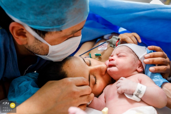 Photo by: <a href="https://www.fpja.com/documentary-family-photography-contests/priscilla-mondo/sao-paulo/2102481">Priscilla Mondo - Brazil</a> Couple come close together with their new baby just minutes after birth | Sao Paulo Birth Photographer